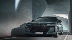 Dunkelgrauer BMW 7er Limousine fährt durch einen modernen, betonierten Tunnel.