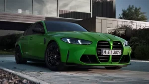 Grüner BMW 3er M Limousine auf einer Einfahrt vor einem modernen Gebäude.