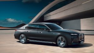 Schwarze BMW Limousine vor modernem Gebäude bei sonnigem Wetter.