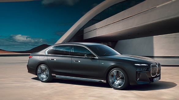 Schwarze BMW Limousine vor modernem Gebäude bei sonnigem Wetter.