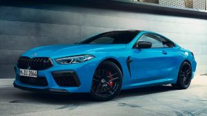 Blaues BMW Coupé in Seitenansicht vor grauer Wand; schwarzes Dach, rote Bremssättel.