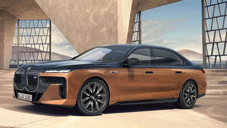 Luxuriöser, zweifarbiger BMW i7 M70 xDrive vor moderner Architektur.