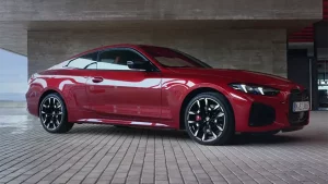 Rotes BMW 4er Coupé in moderner Umgebung, seitliche Ansicht.