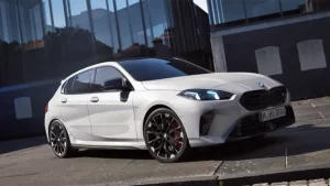 Weiße BMW Limousine auf städtischer Straße vor modernem Gebäude, seitliche Ansicht.