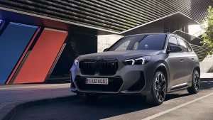 Grauer BMW X1 M35i xDrive steht vor einem modernen Gebäude mit bunten Streifen in Essen.