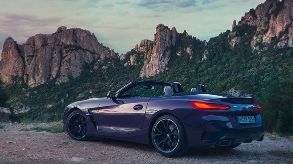 Lila BMW Z4 Roadster vor Felskulisse bei Sonnenuntergang.